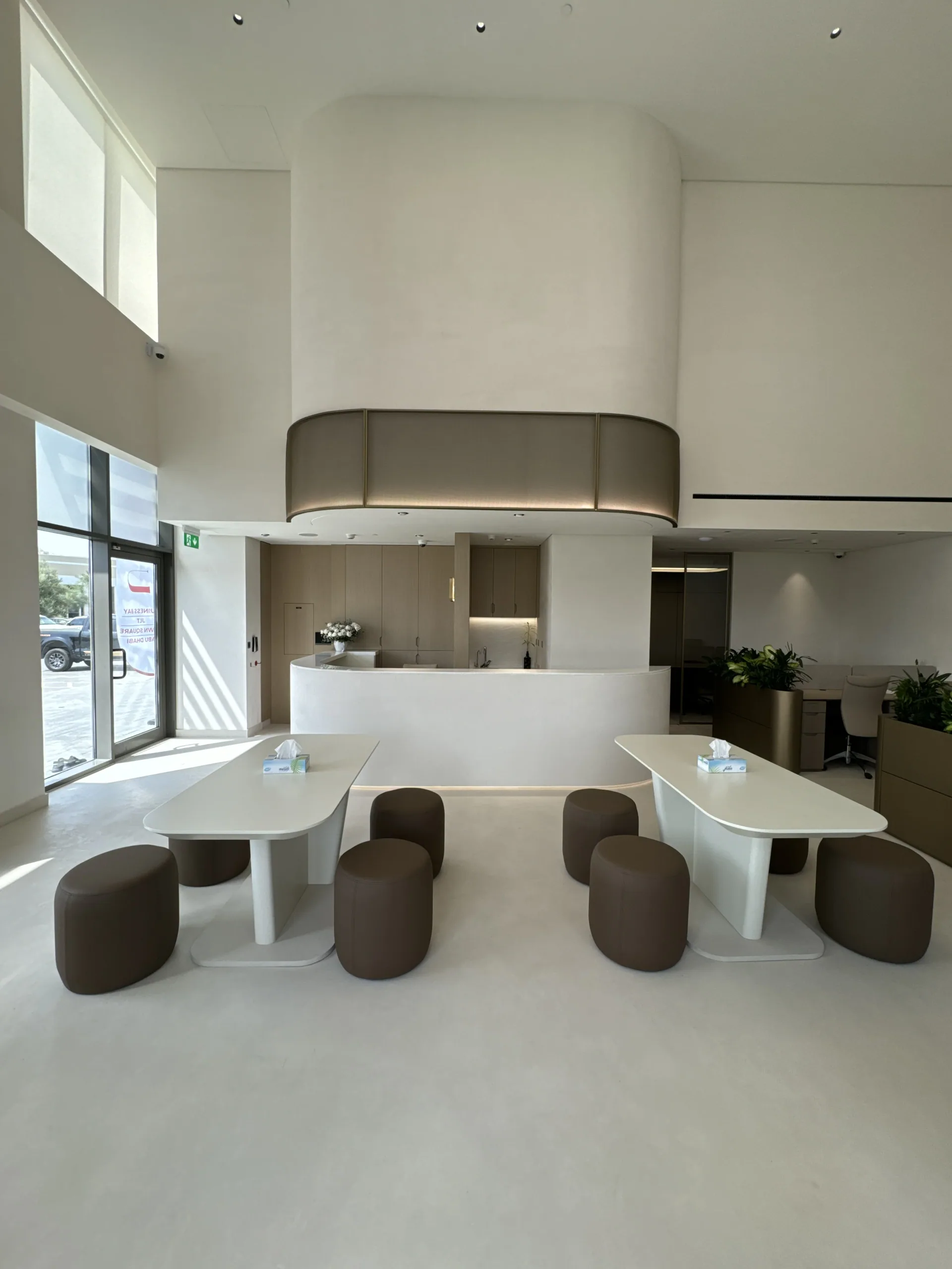 Double-height reception finished in seamless microcement walls and floor
