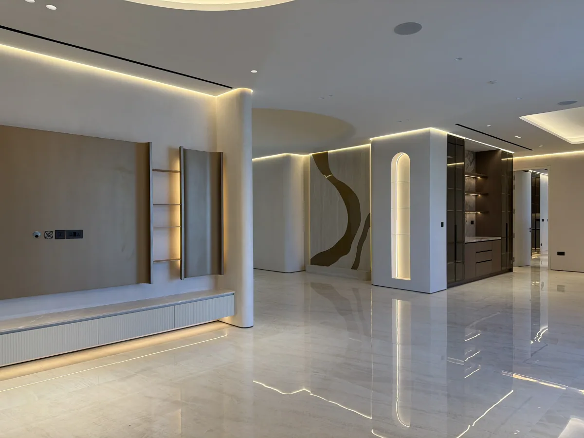 Grand reception hall with polished marble floors, curved plaster columns and a backlit feature wall